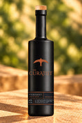 The Curatist Verdant Edition bottle in dappled light