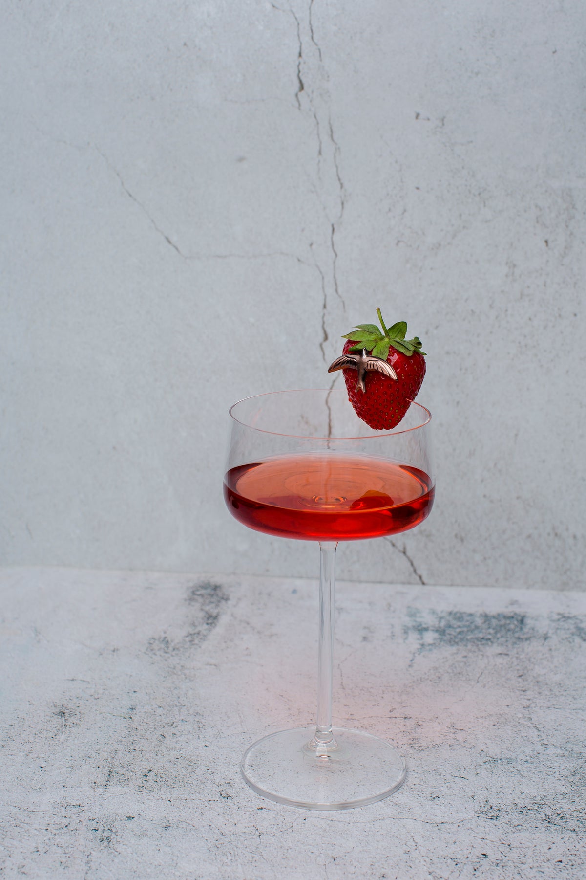 The Curatist Strawberry Daiquiri in a coupe with a fresh strawberry