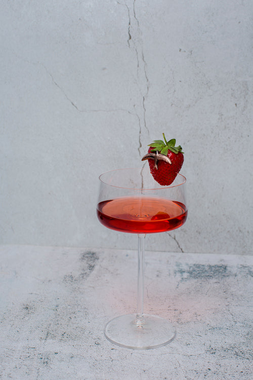 The Curatist Strawberry Daiquiri in a coupe with a fresh strawberry